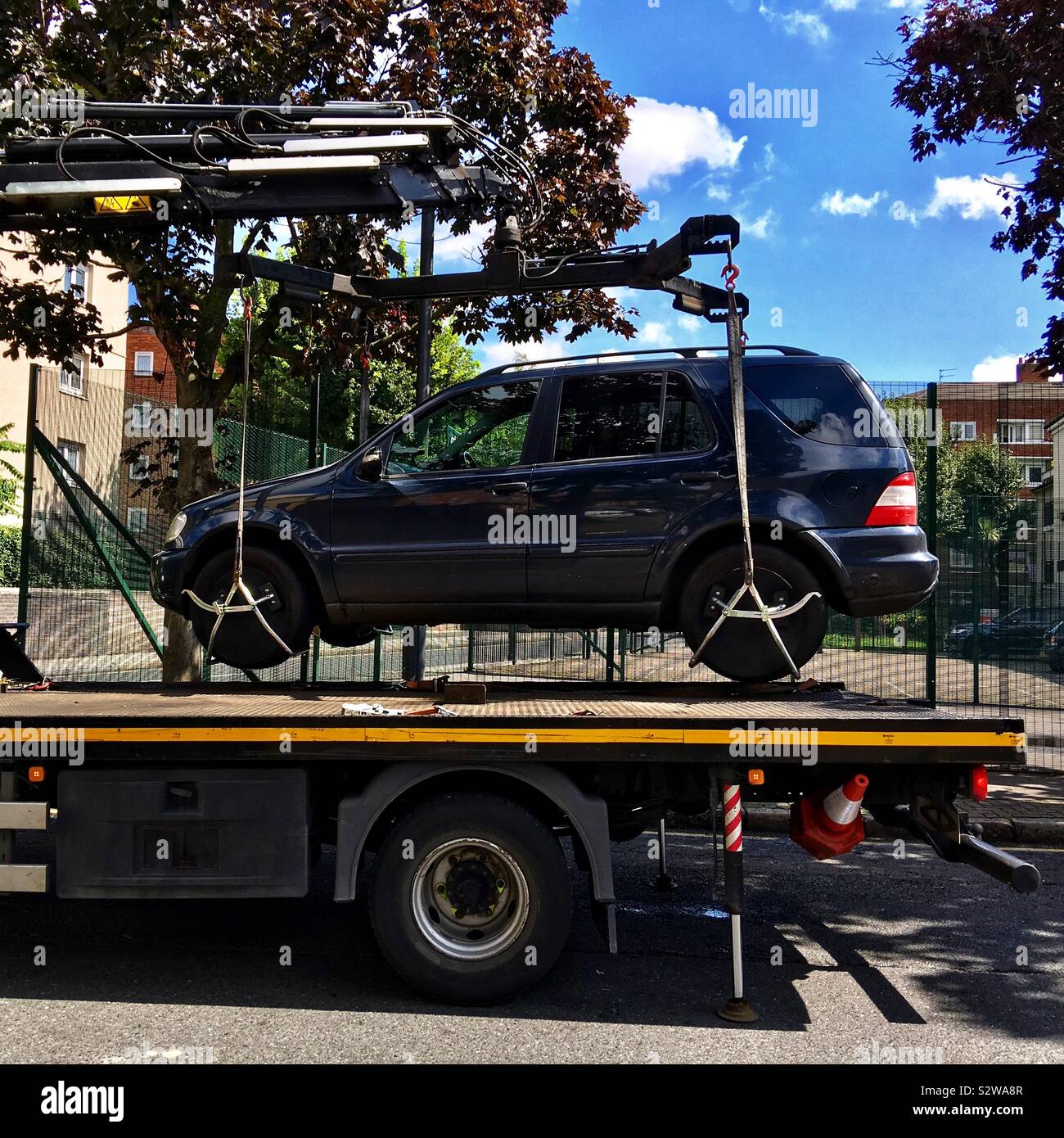 Car that was parked illegally is being lifted up onto a tow truck in Shoreditch, London, England UK Stock Photo
