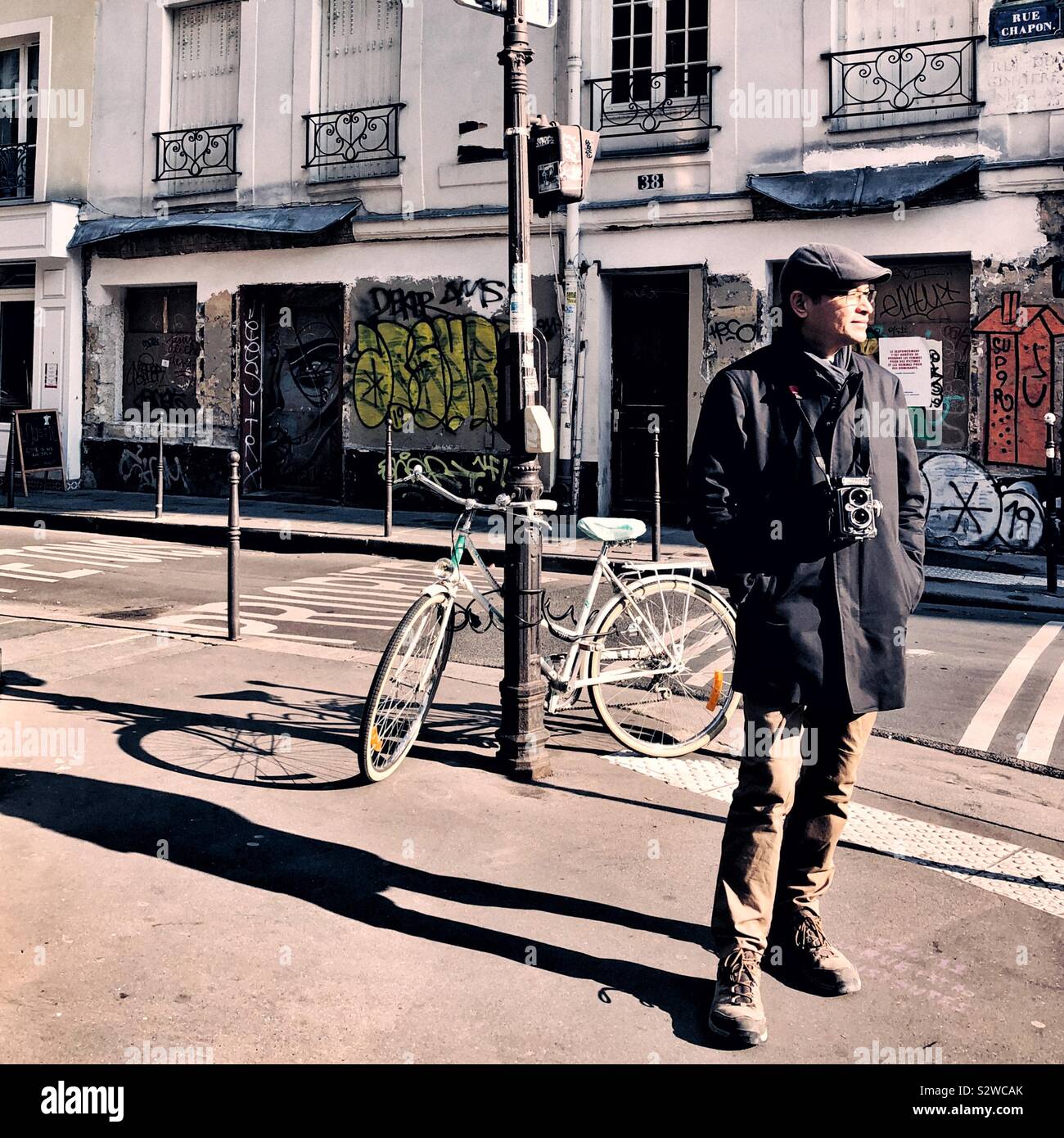 Tourist with vintage camera on sidewalk in Paris - Smartphone Captured Stock Image