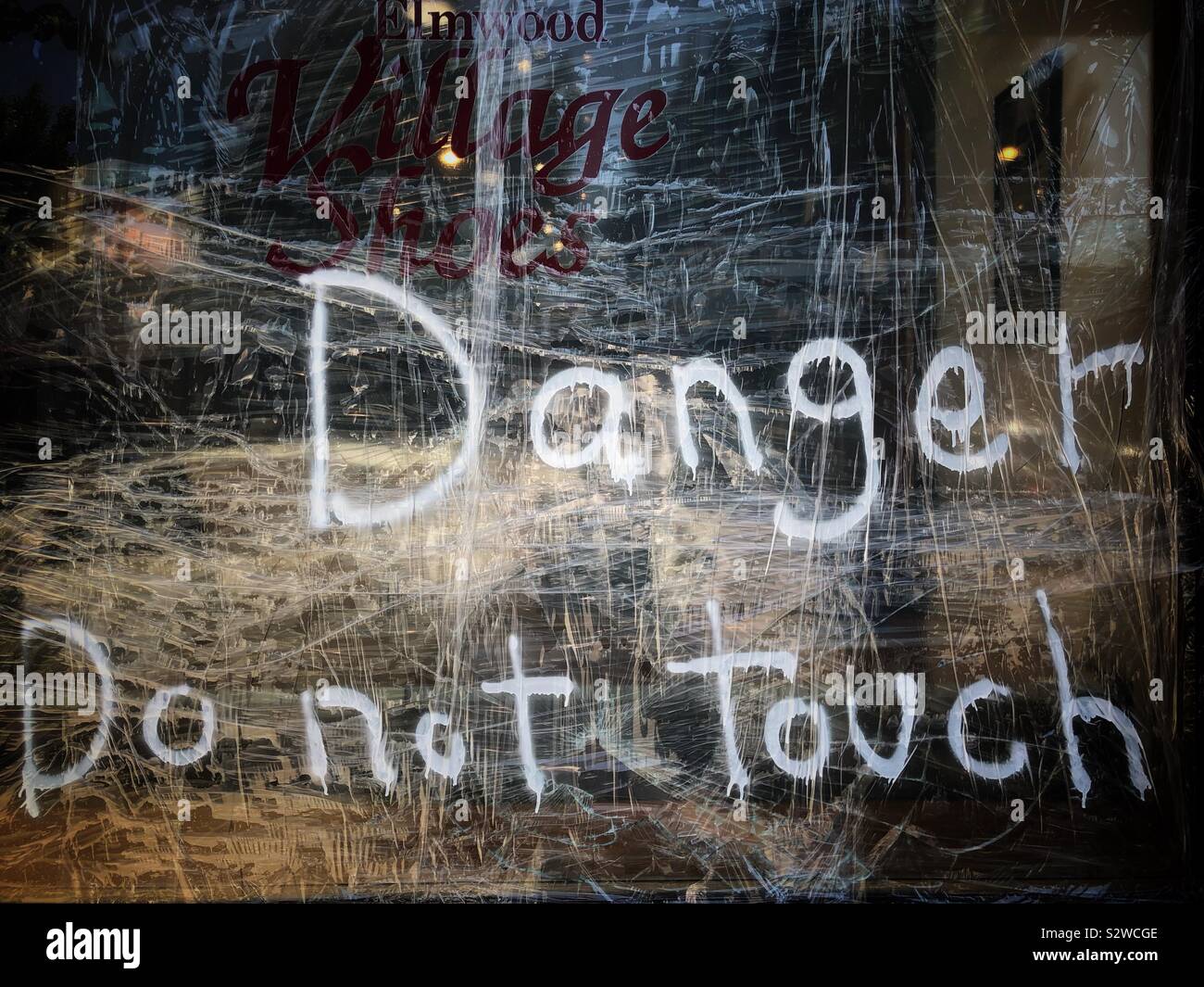 A taped up broken window marked with 'Danger Do Not Touch' in Berkeley, California. - Smartphone Captured Stock Image