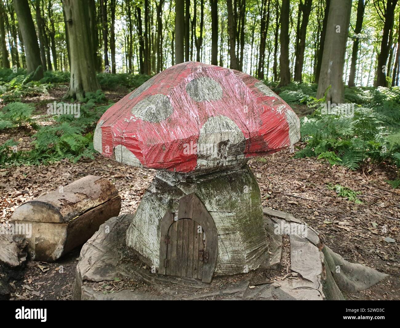 Wooden mushroom in the woods with fairy door Stock Photo