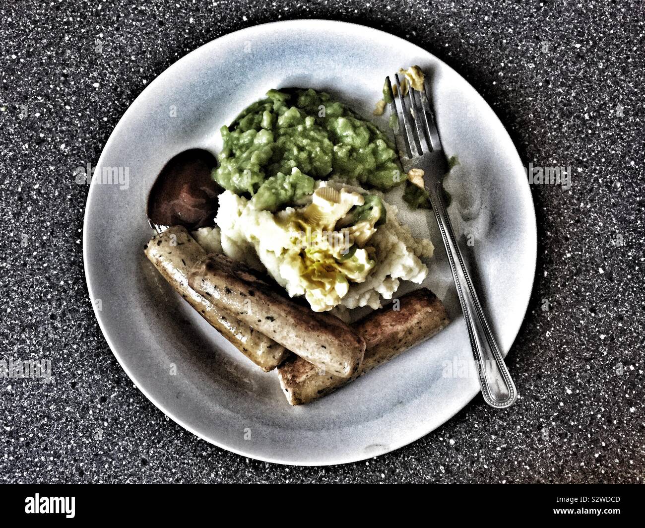 Veggie sausage mash and peas with margarine and brown sauce in a white plate from above - Smartphone Captured Stock Image
