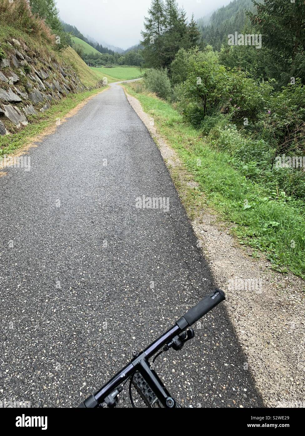 Cycling on a mountain road on a cloudy summer day. - Smartphone Captured Stock Image