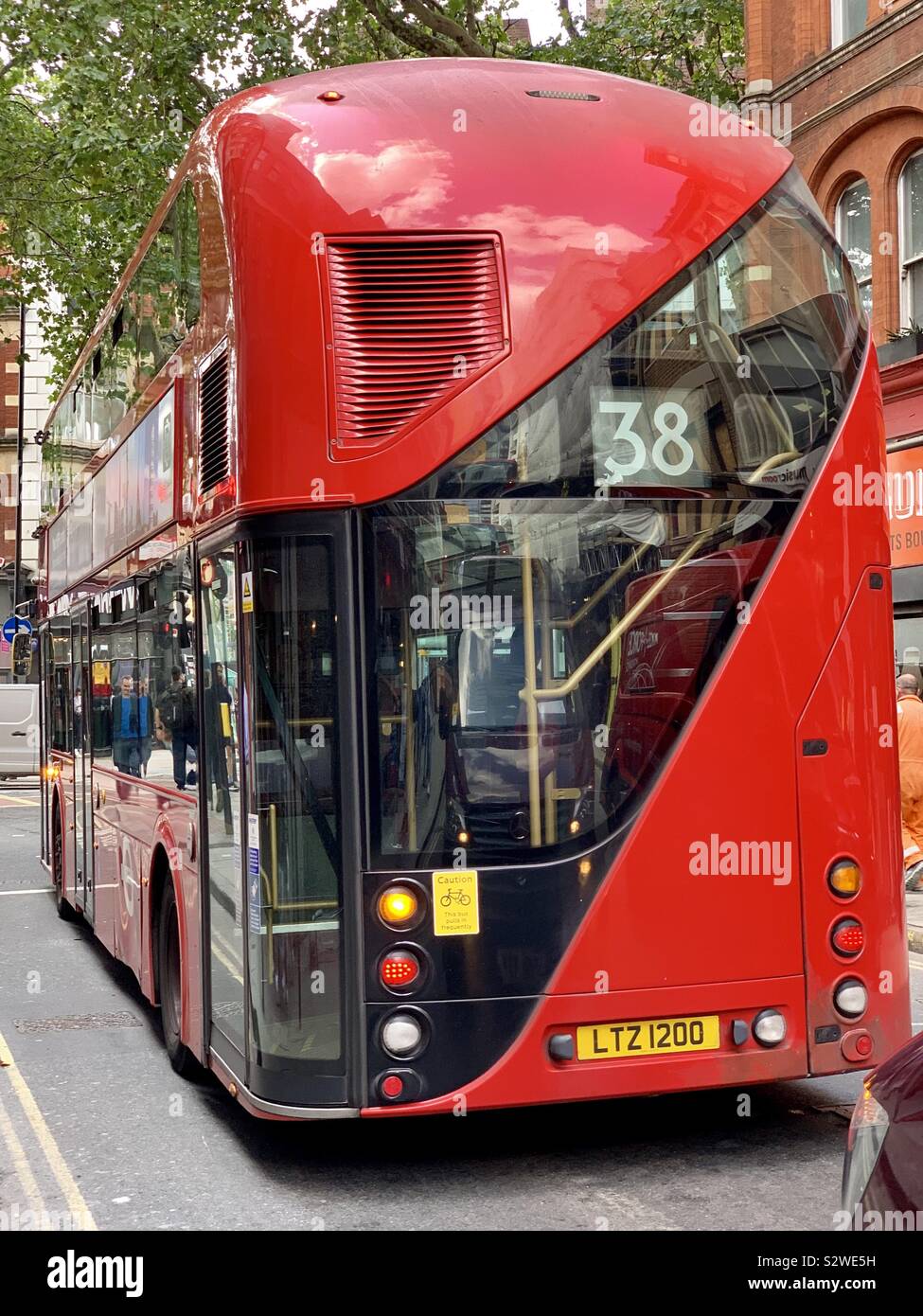 London, UK - 21 August 2019: Number 38 red London double decker bus for Victoria queuing in Denmark Street. - Smartphone Captured Stock Image