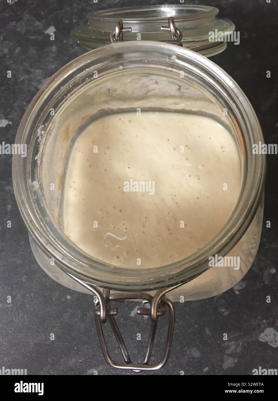 Sourdough starter in a glass jar a live culture of water and flour