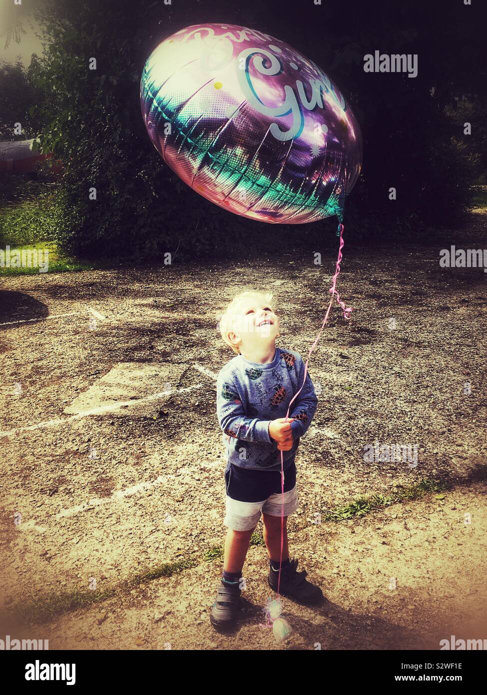 Two year old boy with a large helium balloon. - Smartphone Captured Stock Image