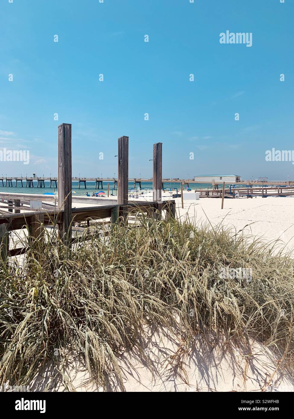 Beach view with outdoor shower area and view of distant pier - Smartphone Captured Stock Image