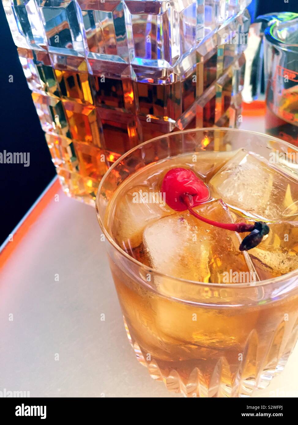 Close up of a Kentucky bourbon Manhattan on the rocks in front of the crystal decanter of bourbon, USA - Smartphone Captured Stock Image