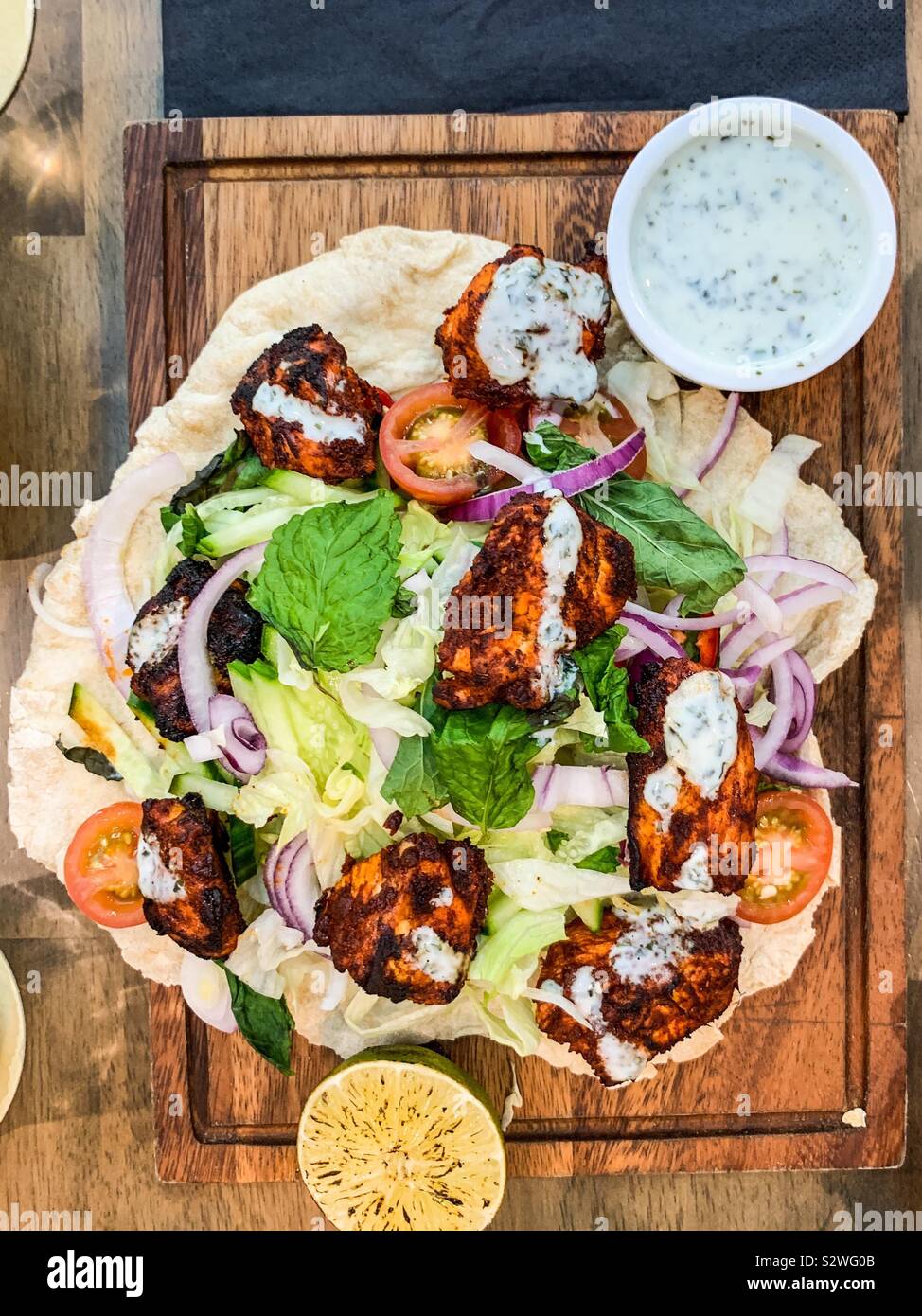 Chicken tikka in a flat bread and salad Stock Photo