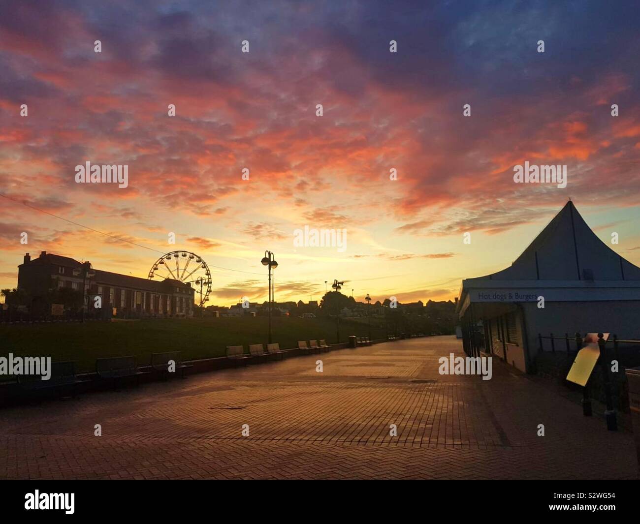 Dawn breaking over Barry Island funfair and promenade, South Wales. - Smartphone Captured Stock Image