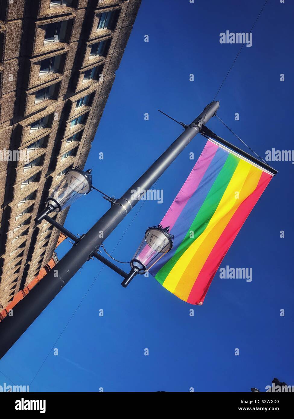 LGBT flag flying against a blue sky during Cardiff Pride day. Stock Photo