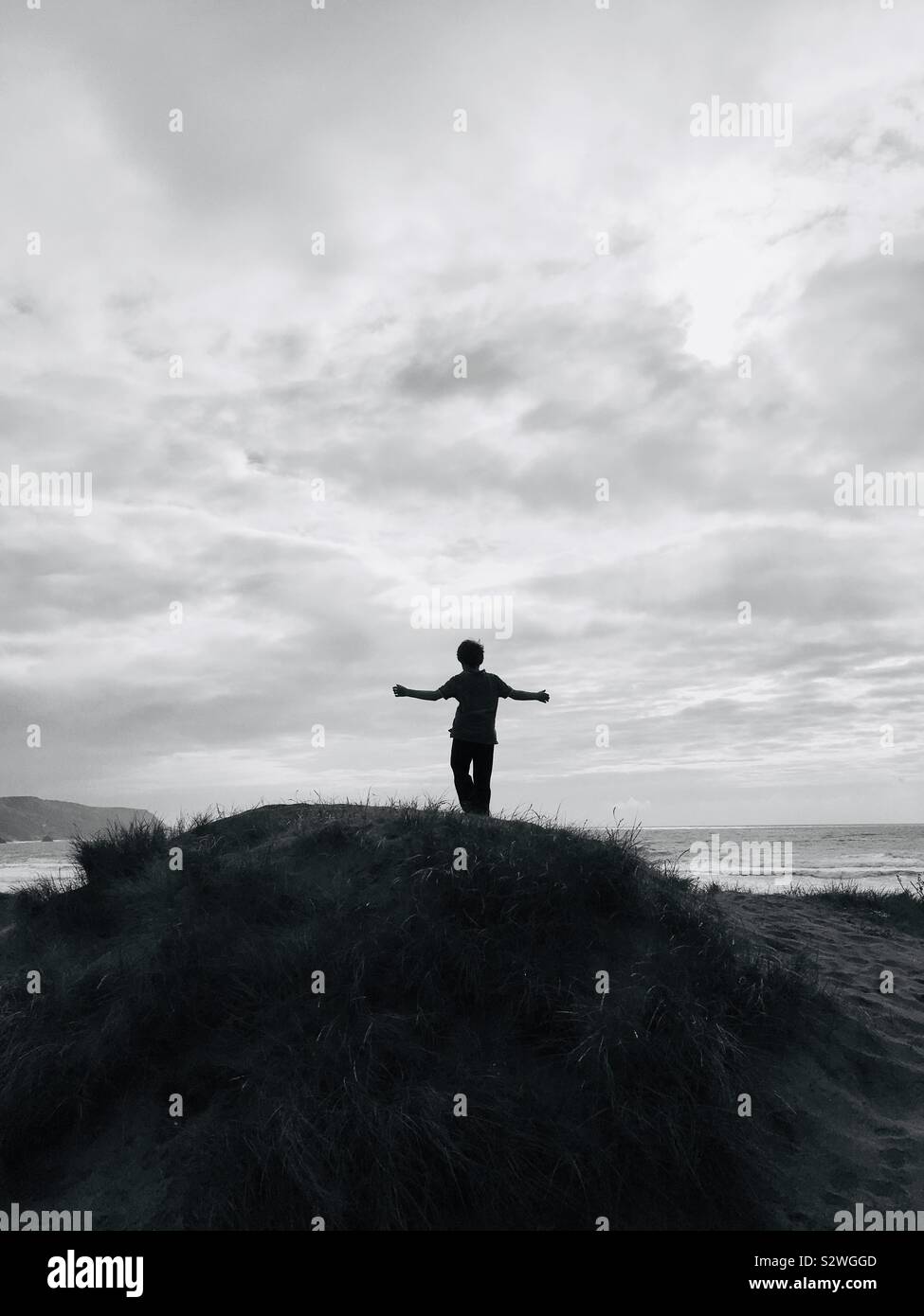 Boy looking out to sea on a sand dune Cornwall UK - Smartphone Captured Stock Image