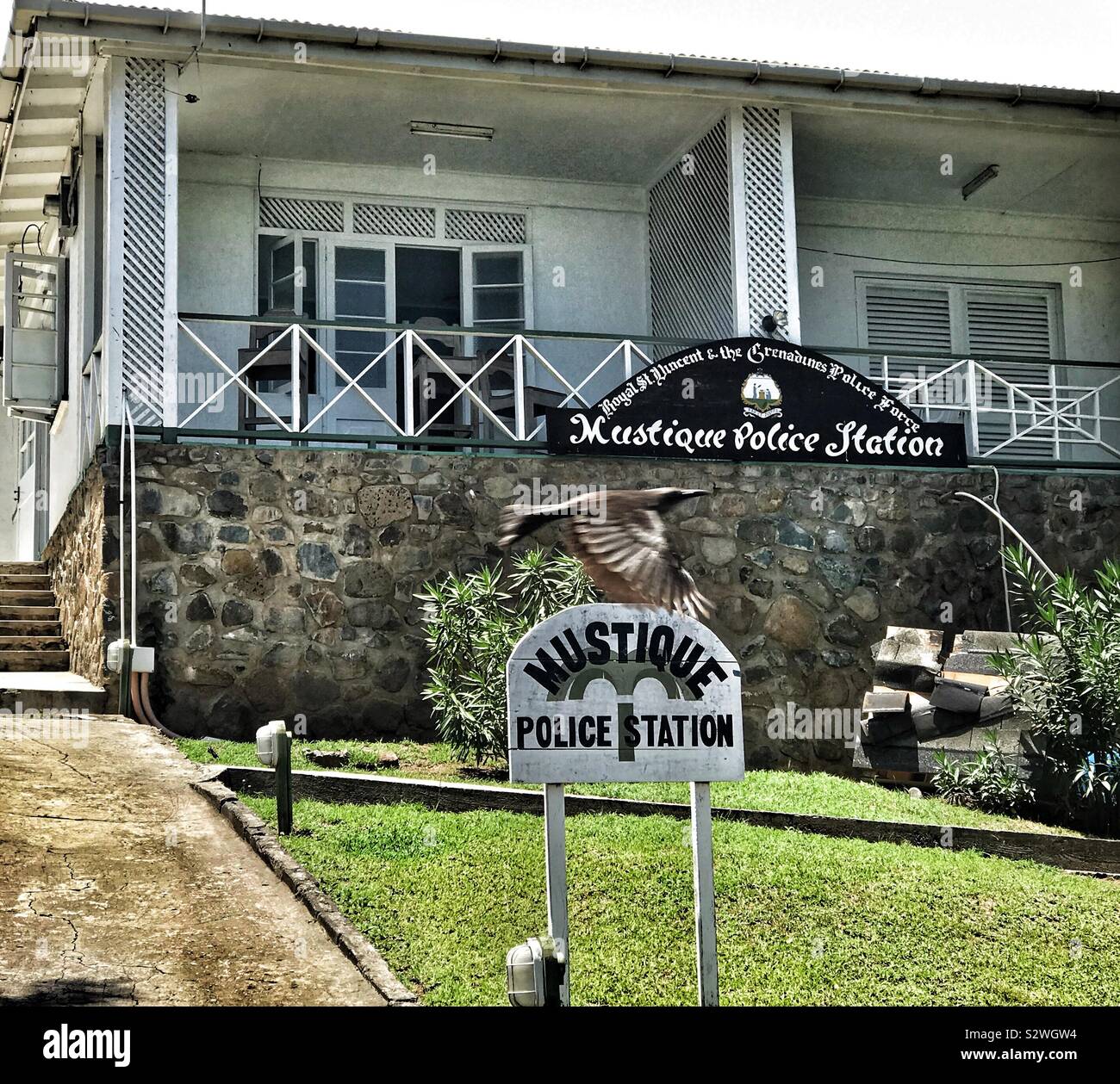 Mustique Police Station with A Bird Flying Over The Sign - Mustique, St.Vincent and the Grenadines - Smartphone Captured Stock Image
