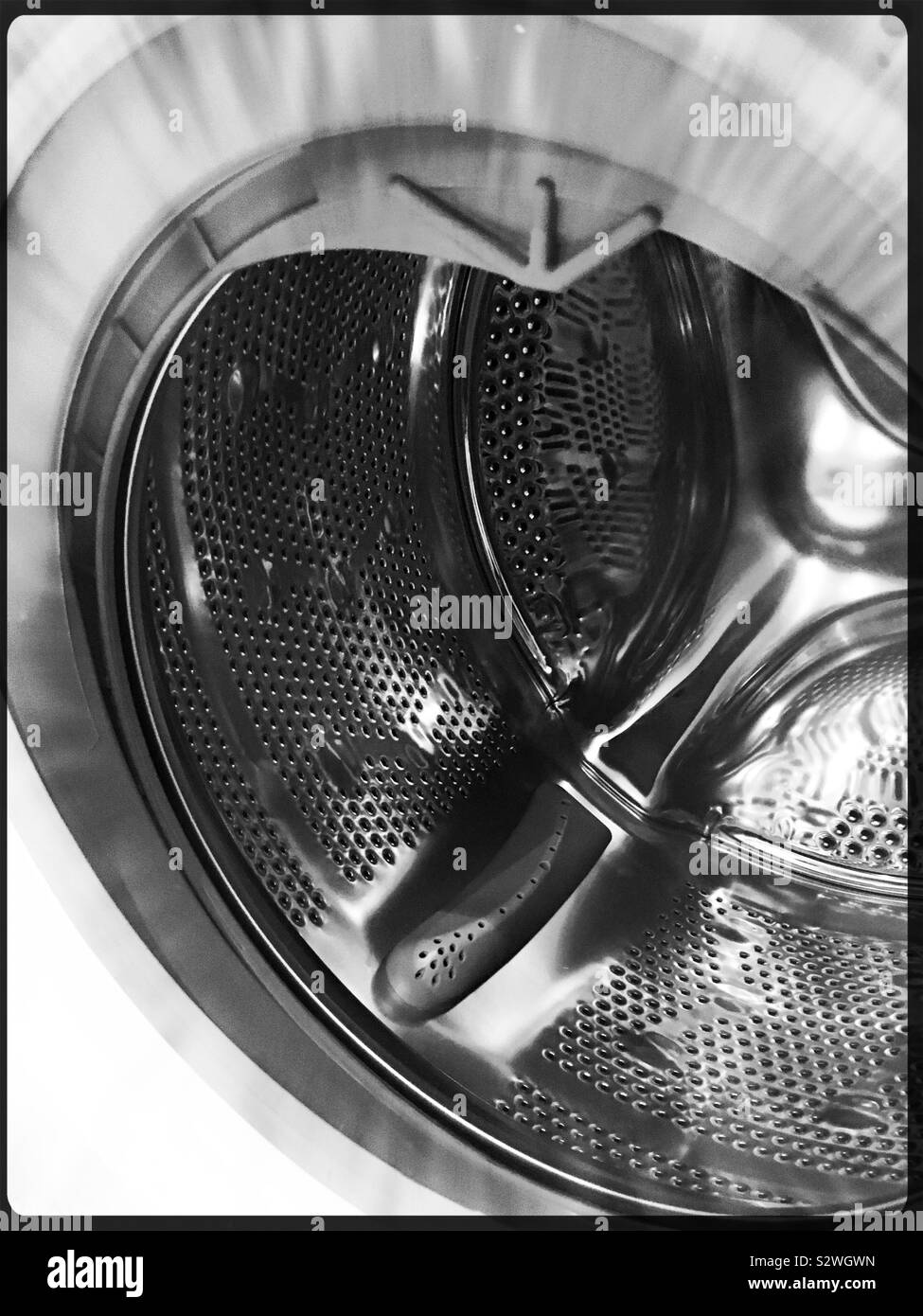 Shiny metal inside the drum of a washing machine Stock Photo