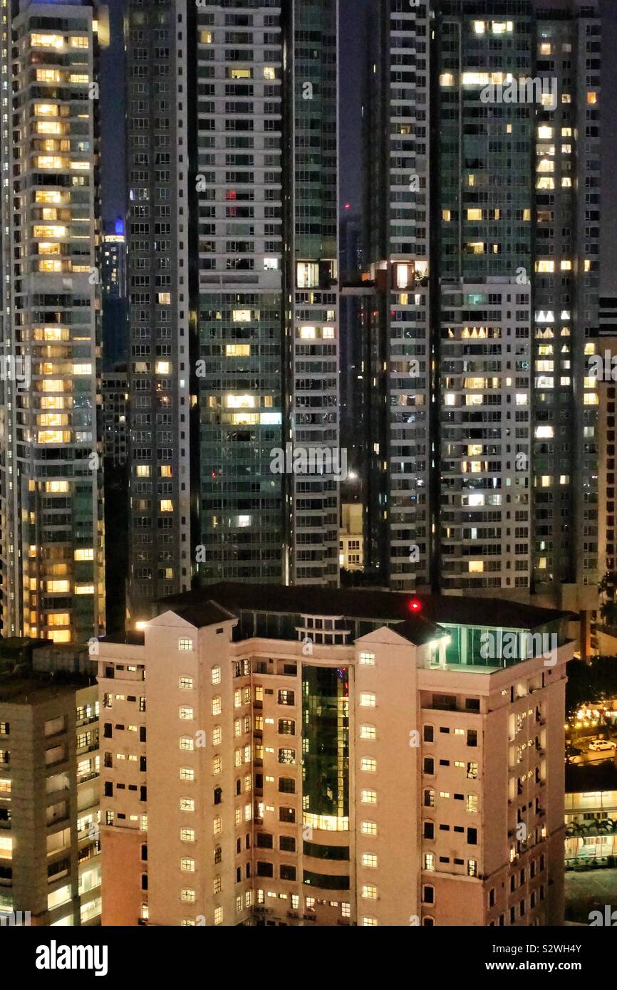 Large facade of different apartment buildings by night Stock Photo