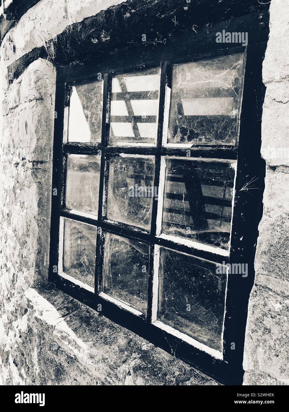 Cobwebs on the Window Of Stevington Windmill Bedfordshire UK with The Sail in the Reflection - Smartphone Captured Stock Image