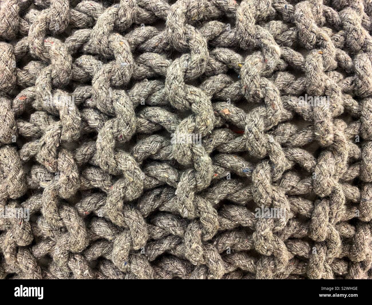 Grey yarn displayed in a beautiful loop macrame pattern. - Smartphone Captured Stock Image