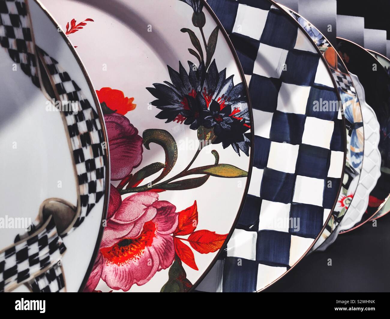 Display of brightly colored patterned plates for sale at Mackenzie Childs in Soho, NYC, USA - Smartphone Captured Stock Image