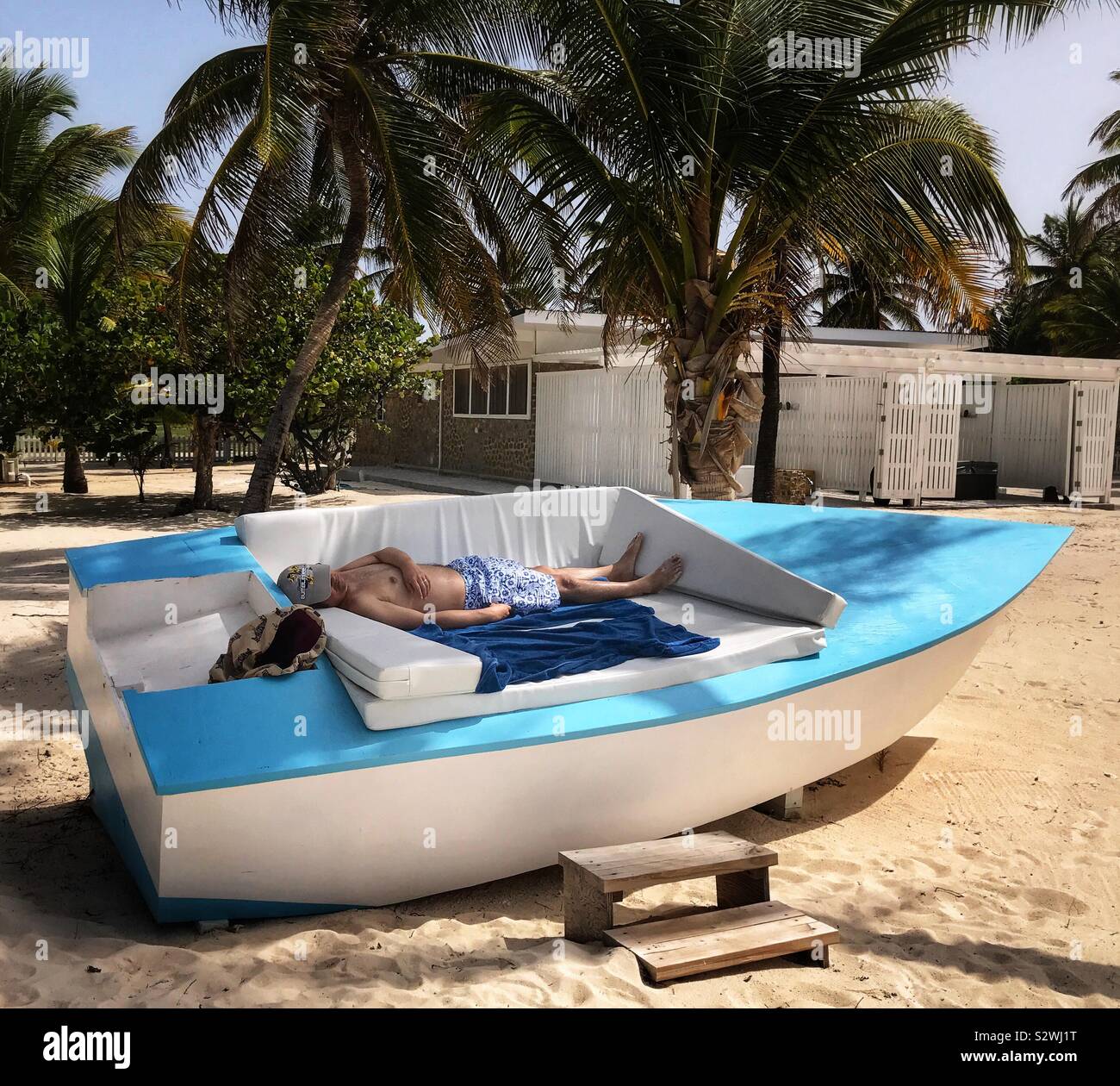 Man Sleeping on A Boat shaped Lounger on The Beach - Palm Island Resort and Spa - St.Vincent and the Grenadines - Smartphone Captured Stock Image