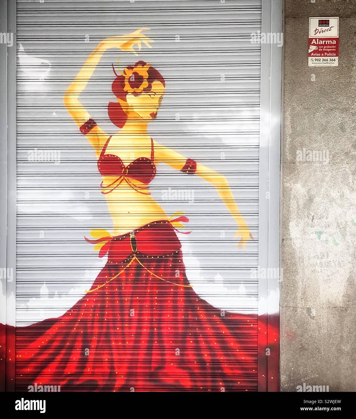 Shutter art adorns a dance Academy in Madrid, Spain and portrays a shapely female dancer dressed in red exposing her midriff . Stock Photo