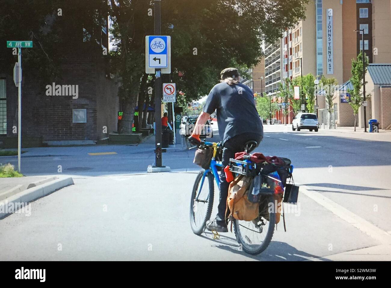 Street photography in Kensington in Calgary, Alberta, Canada,  cycler with saddlebags on his bicycle - Smartphone Captured Stock Image