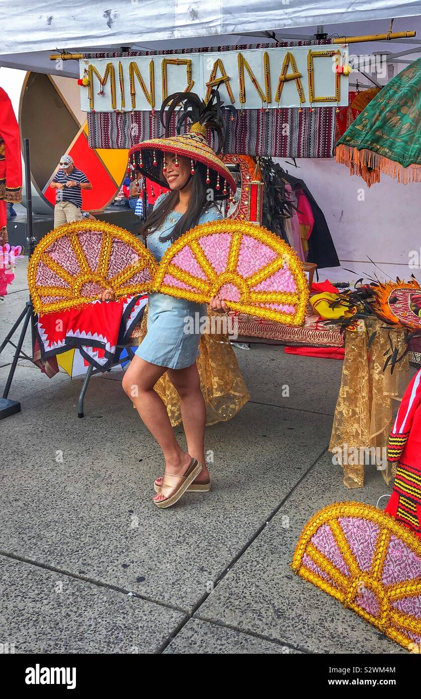 A woman poses in front of a booth at the Filipino cultural festival at