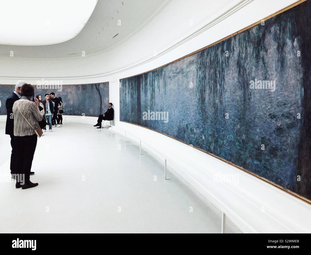 Visitors admire Claude Monet's Water Lilies in  the Orangerie museum in Paris Stock Photo