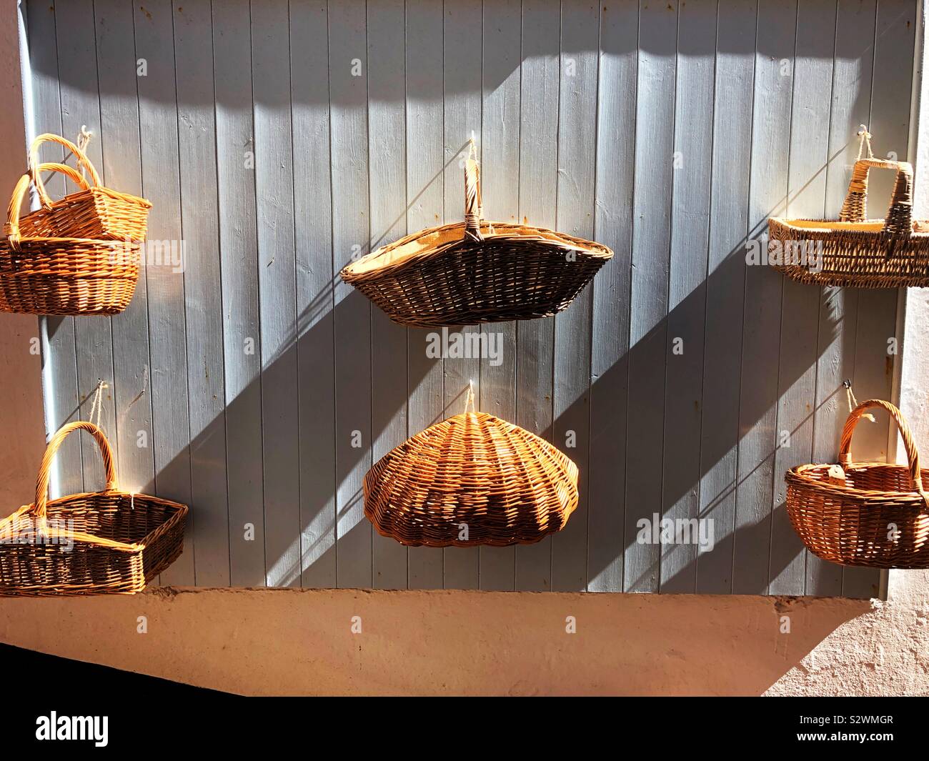Wicker baskets hanging on a wall for sale - Smartphone Captured Stock Image