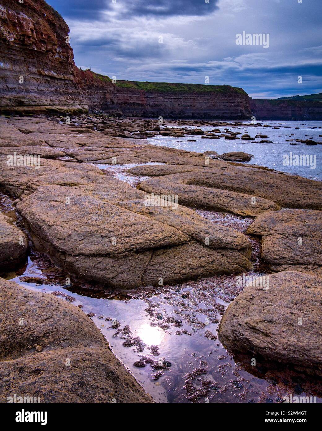 Wave cut platform below cliffs on the beach at Staithes in North Yorkshire England UK - Smartphone Captured Stock Image