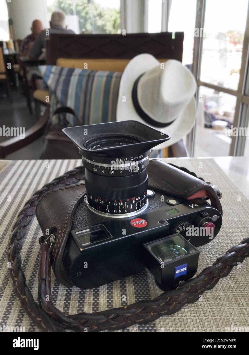 Leica Camera and tropical sun hat. Concept of a traveling photographer. - Smartphone Captured Stock Image