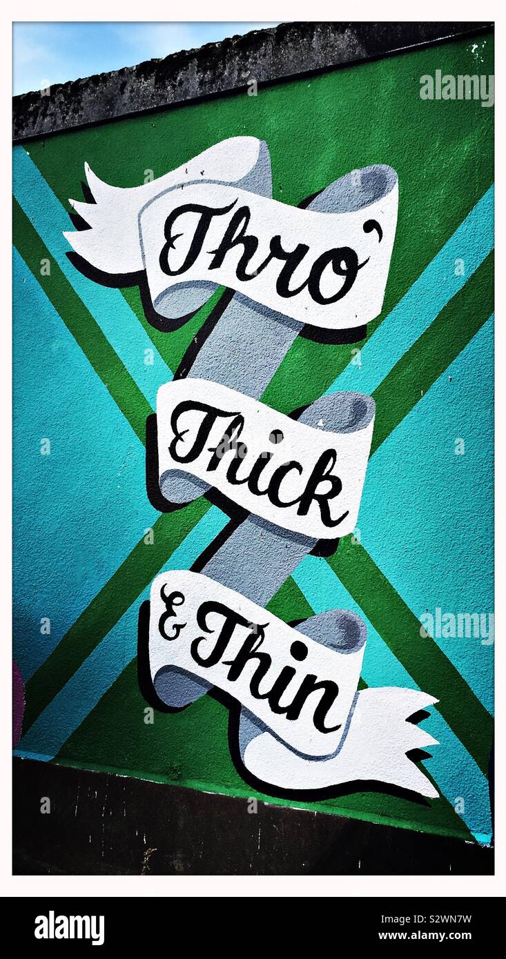 A section of a street art wall mural in Bristol, UK, with the words ‘Thro’ Thick & Thin’ Stock Photo