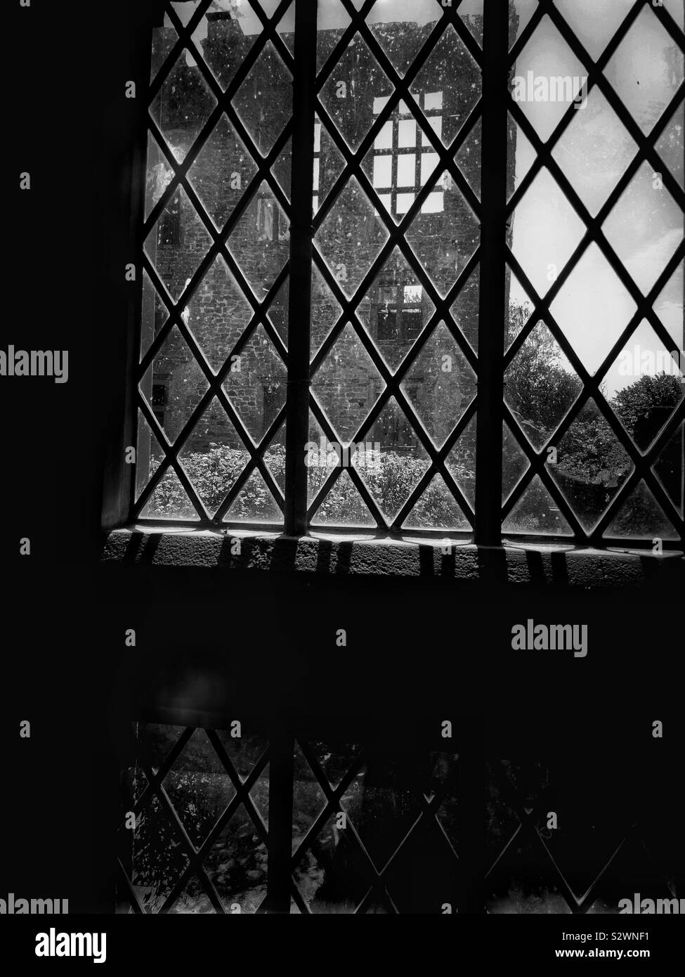 Black and white image ruins of Hardwick Old Hall seen through leaded windows. Tudor period house built between 1587-96 for Bess of Hardwick, Elizabeth Shrewsbury Stock Photo