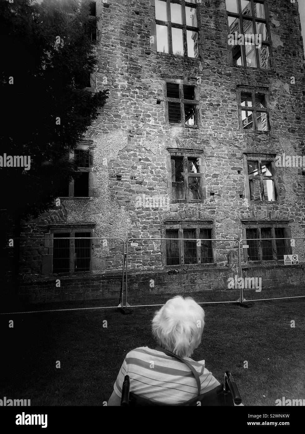 Woman in wheelchair at Hardwick Old Hall, Derbyshire, England. Tudor period house built between 1587-96 for Bess of Hardwick, Elizabeth Shrewsbury - Smartphone Captured Stock Image