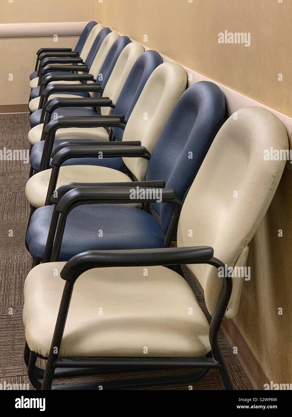 Row of chairs on doctor waiting room empty Stock Photo