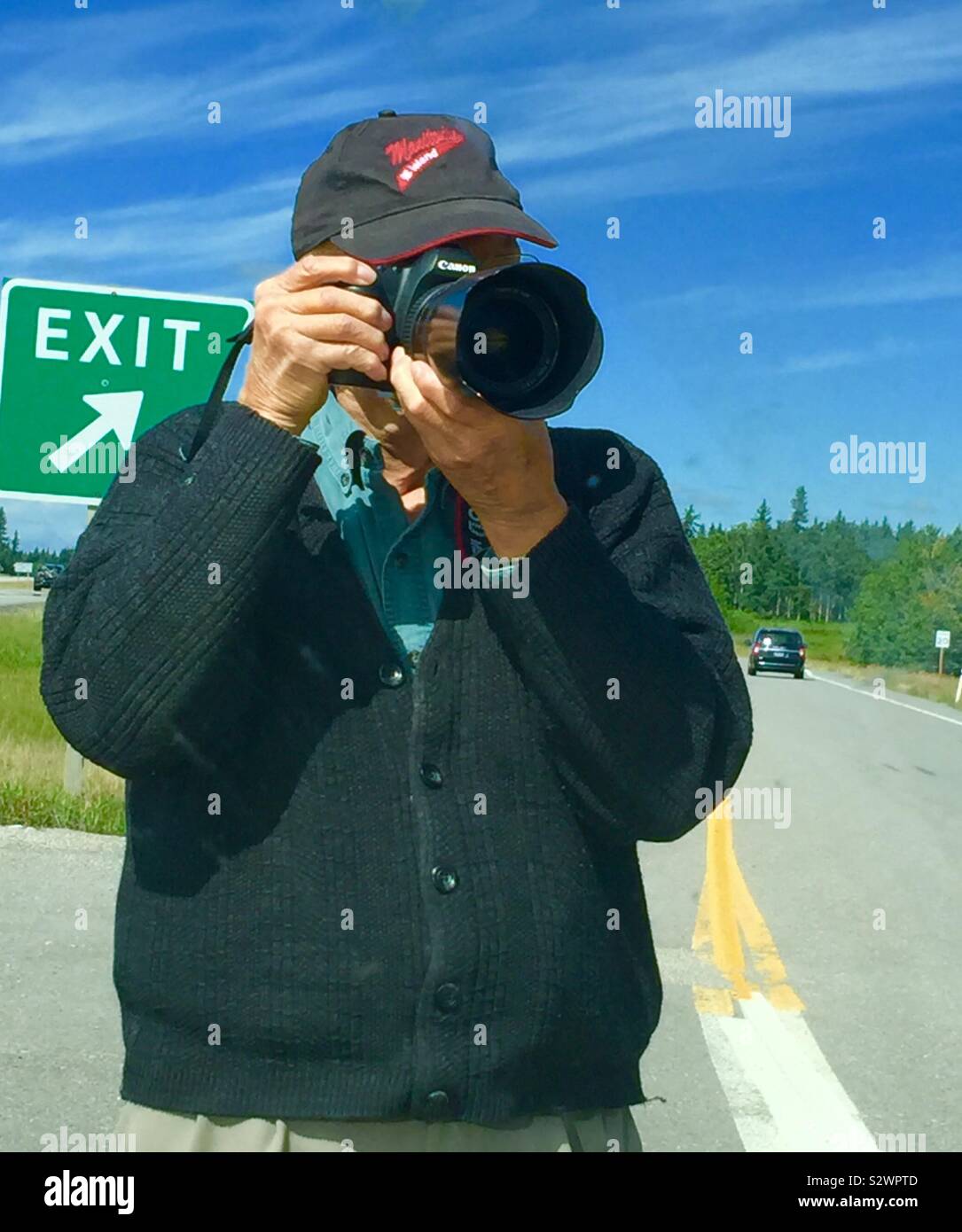 Man photographer with a camera taking a photo - Smartphone Captured Stock Image
