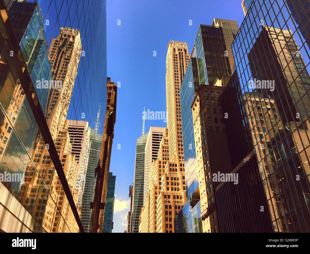Skyscrapers and their reflections in the glass the side of 300 Madison Ave. looking west on 42nd St., Midtown Manhattan, NYC, USA - Smartphone Captured Stock Image