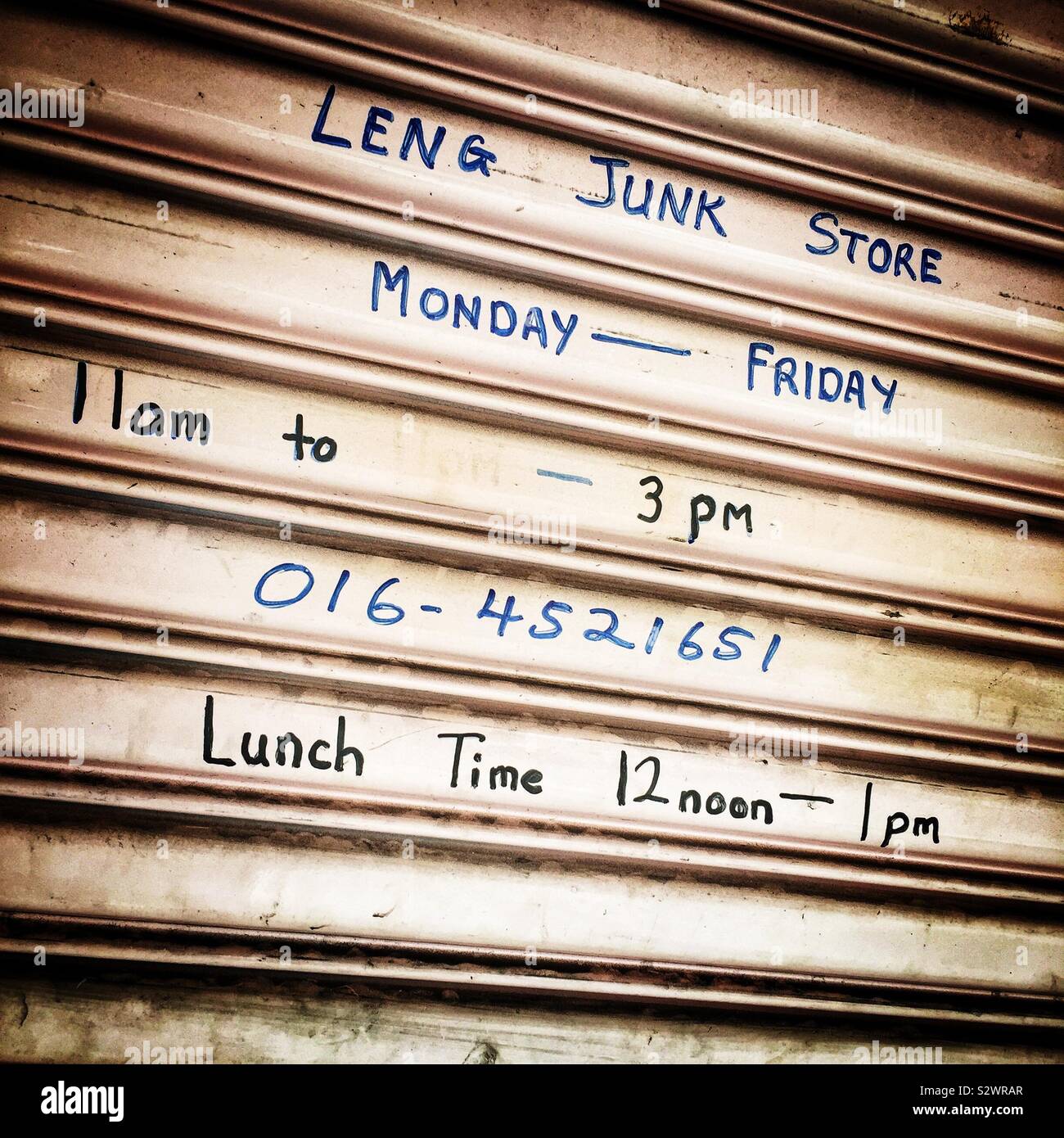 Handwritten sign on a roller shutter in the Old Town of George Town, Penang, Malaysia - Smartphone Captured Stock Image