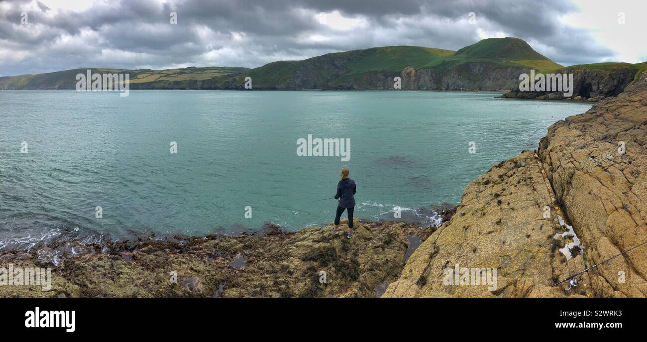Young woman fishing on the Welsh coast, August. - Smartphone Captured Stock Image