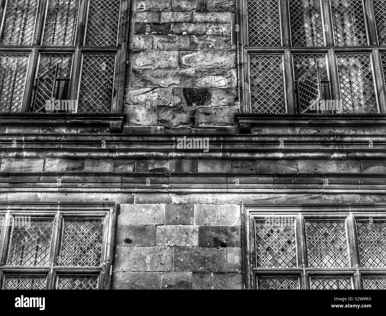 Black and white image of building facade with leaded mullioned windows - Smartphone Captured Stock Image