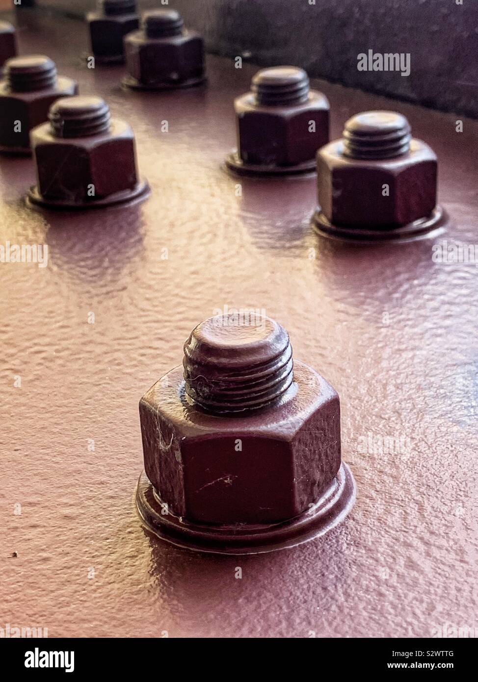 Closeup of painted steel rivets holding up a structure. - Smartphone Captured Stock Image