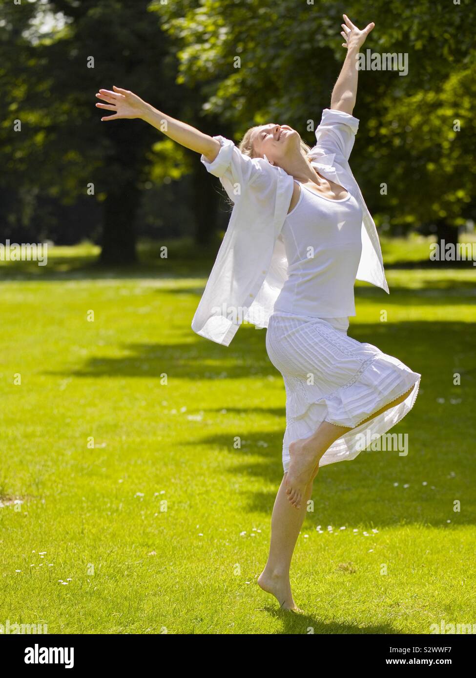 Beautiful blonde woaman dances in sunlight - Smartphone Captured Stock Image