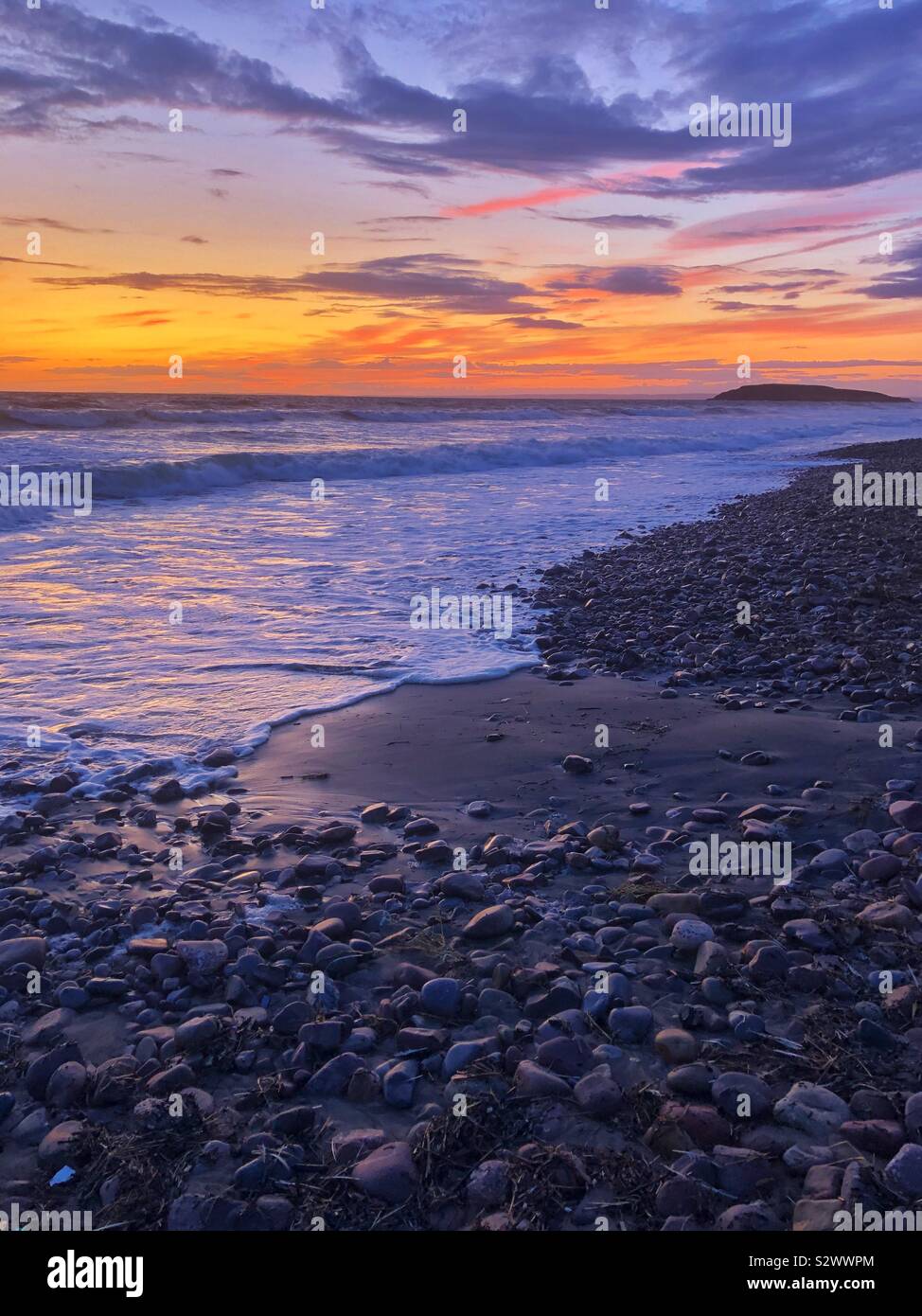 Sunset afterglow at Llangennith beach with Burry Holms in the distance, Gower, Swansea, South West Wales, August. Stock Photo