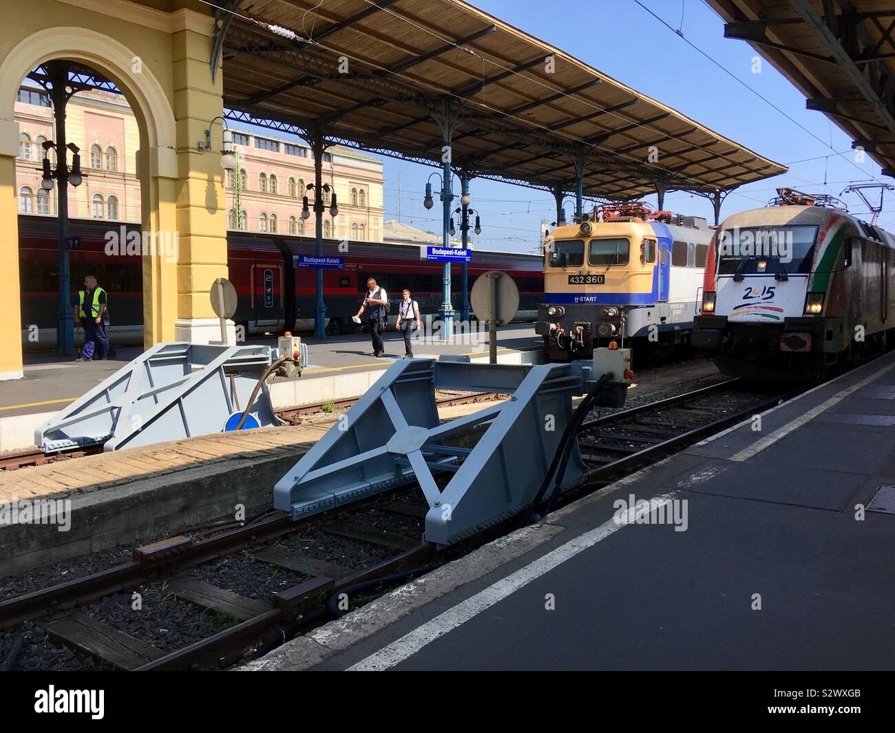 Keleti palyaudvar (railway station) Budapest, Hungary. Electric locomotives at buffer stop bumping post and two conductors ticket inspectors walking. - Smartphone Captured Stock Image