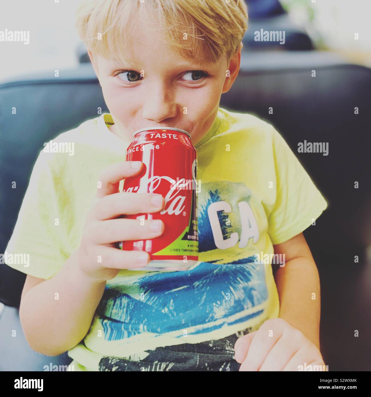 Boy enjoying a naughty can of coke. Stock Photo