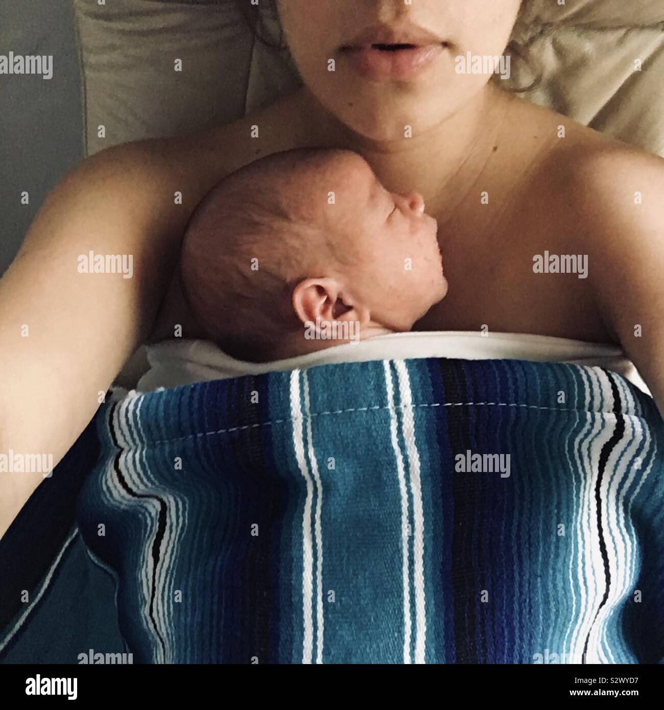 Newborn baby snuggling with mom Stock Photo