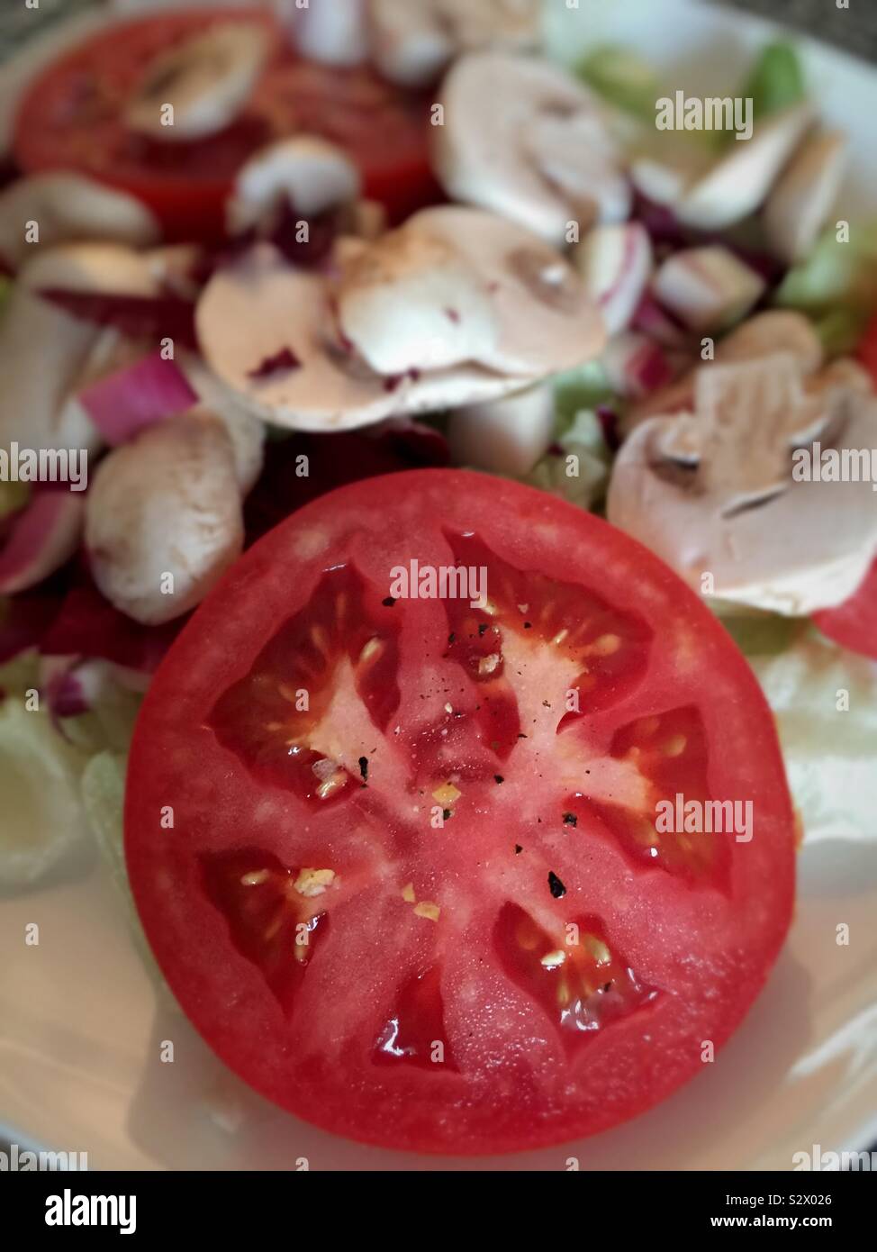 Close up of sliced tomatoes and mushrooms on a cutting board - Smartphone Captured Stock Image