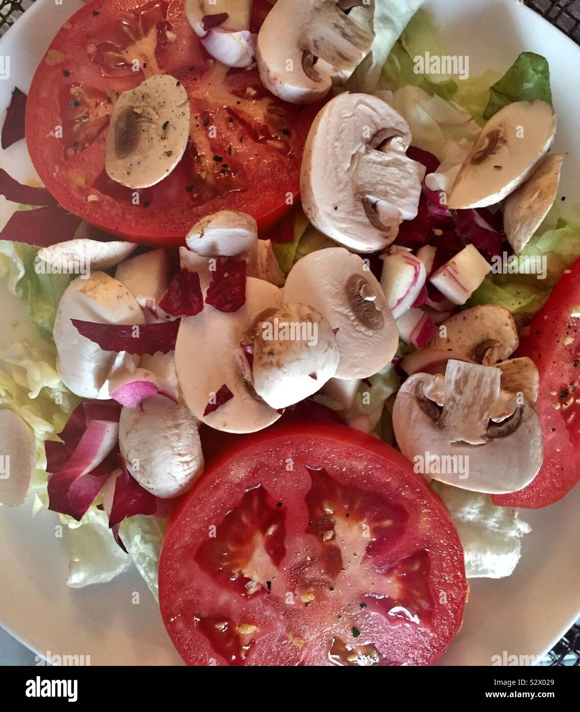 Sliced tomatoes, white wood mushrooms and endive on a cutting board - Smartphone Captured Stock Image