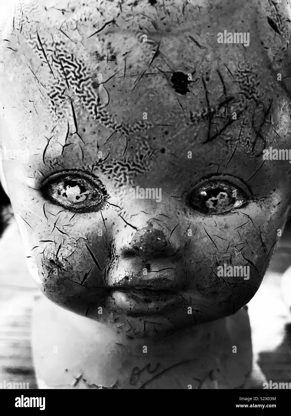 Old baby doll head in bnw Stock Photo