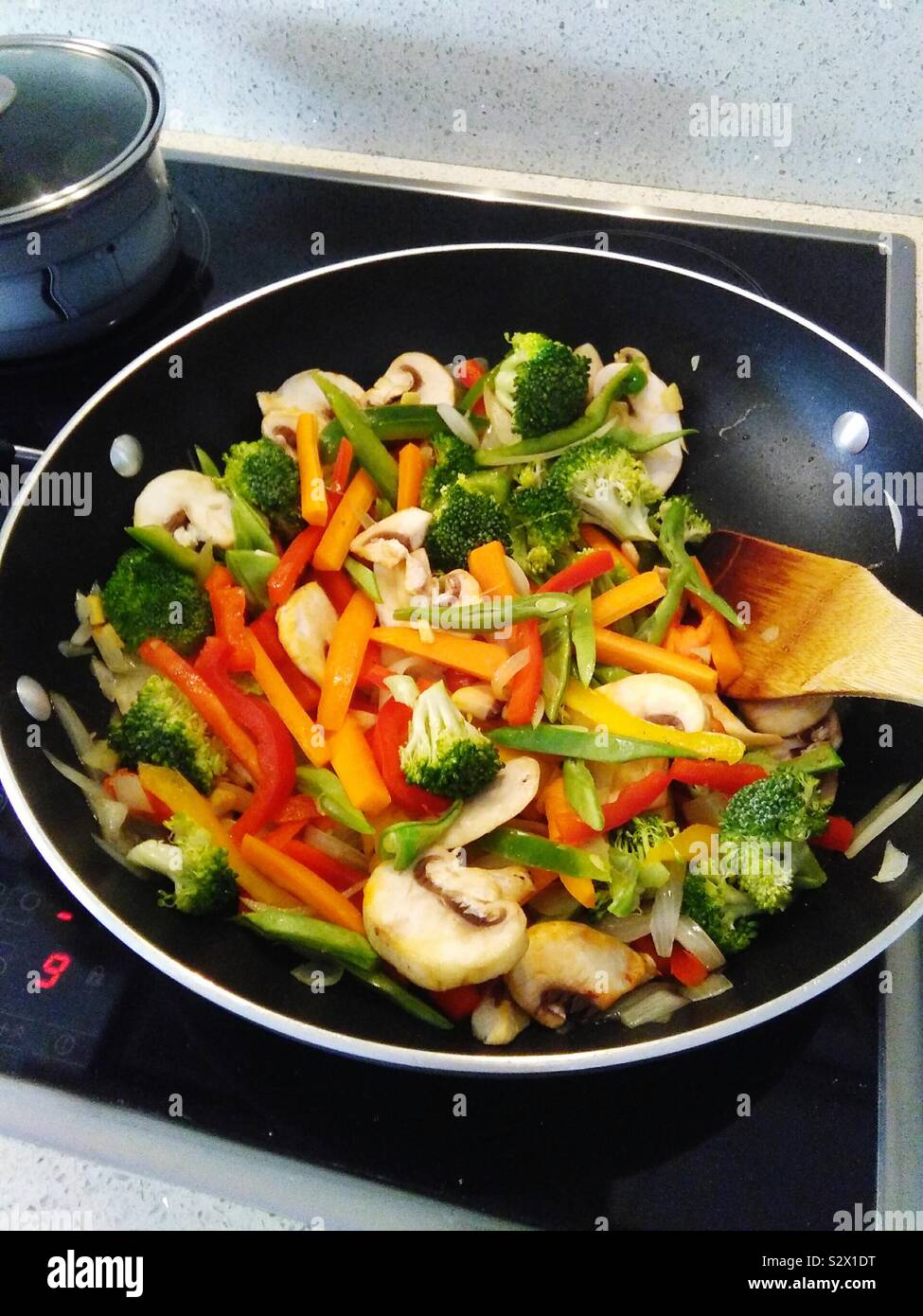 Stir fried vegetables in a wok on an electric job - Smartphone Captured Stock Image