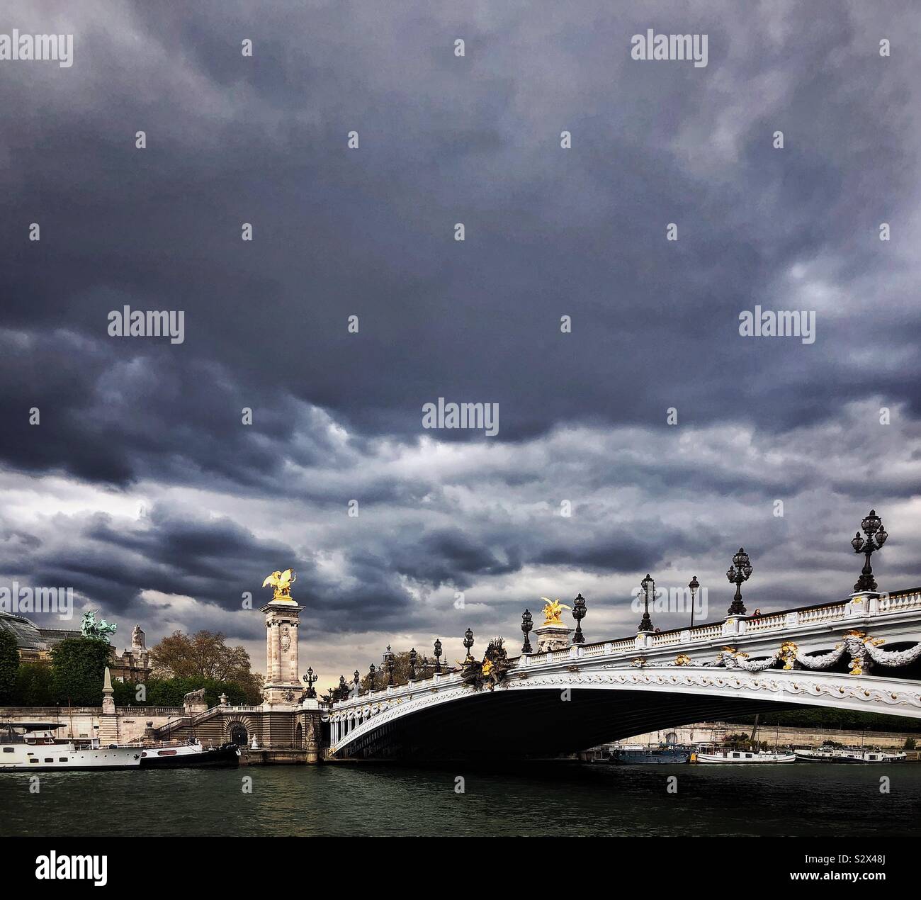 Dramatic sky over Seine river and Pont Alexandre III in Paris Stock Photo