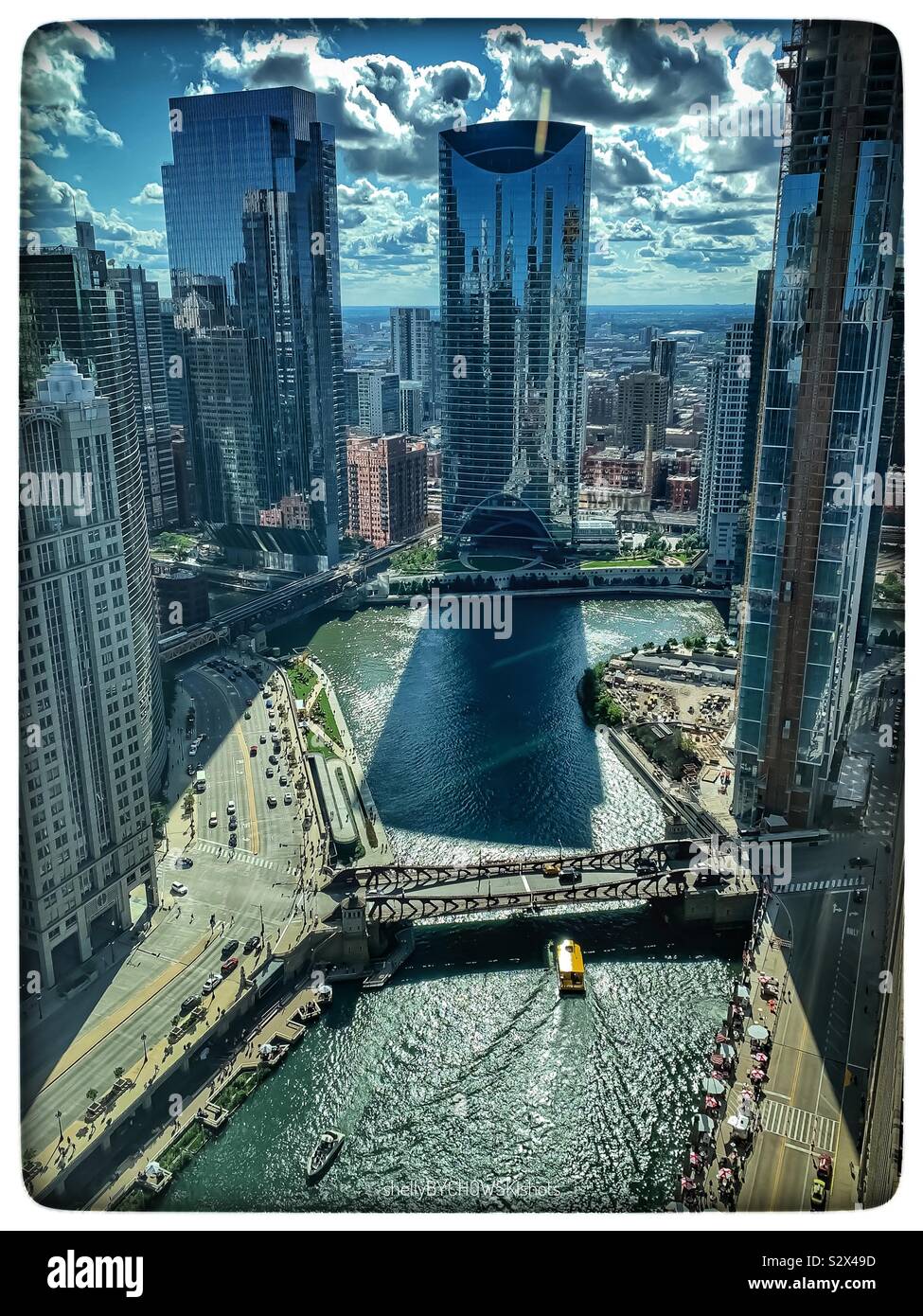 Great building shadow of skyscraper in Chicago Loop as water taxi crosses Chicago River on summer afternoon. Stock Photo